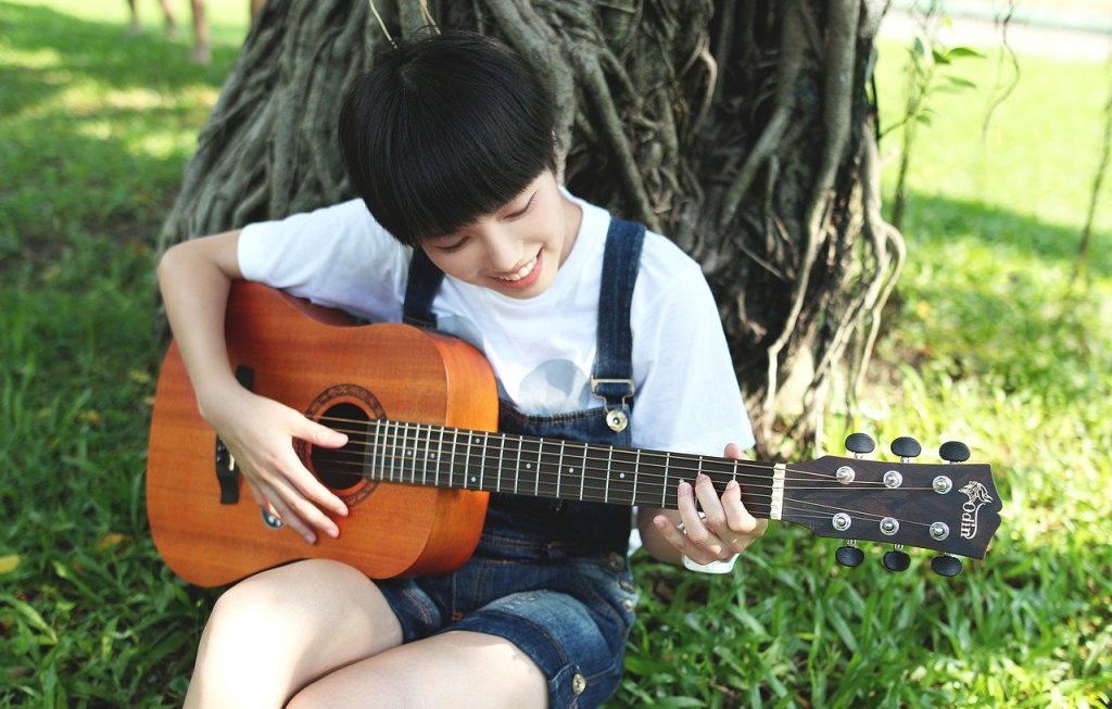 Foto: ragazza che studia la chitarra acustica